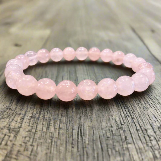 Rose quartz crystal bracelet on wood.